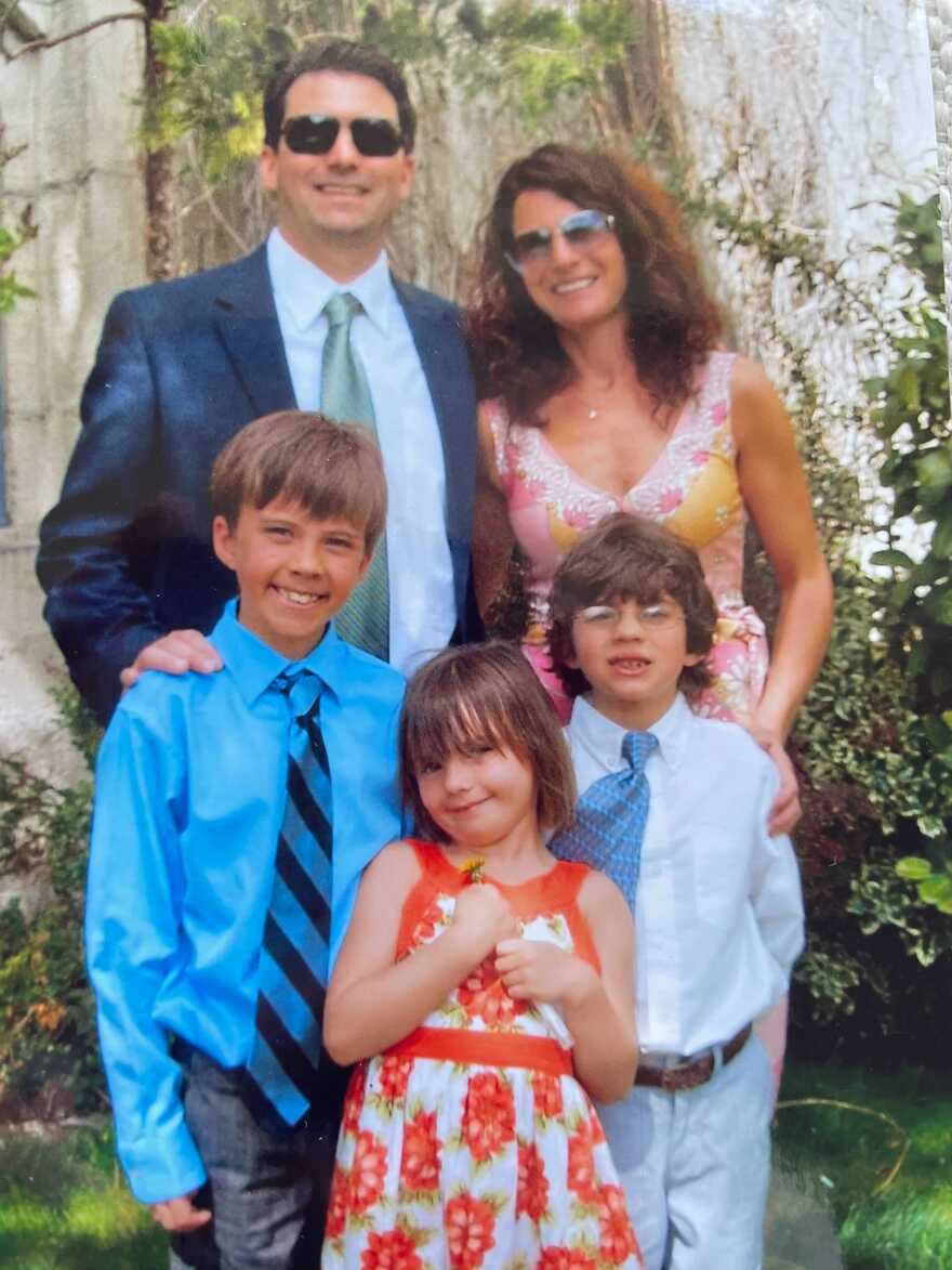 Hudson Heimerman and his family are standing together and smiling at the camera.