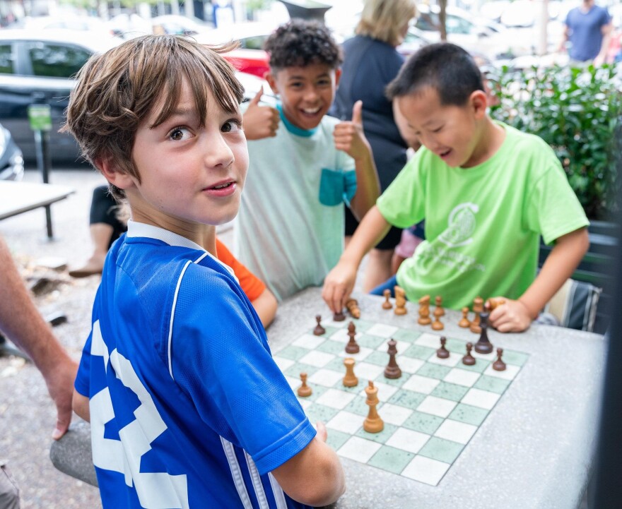 Children enjoying a game of chess in front of the St. Louis Chess Club during the 2019 Sinquefield Cup