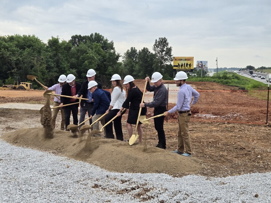 Leaders from the Ozark community "turn dirt" during the groundbreaking ceremony.
