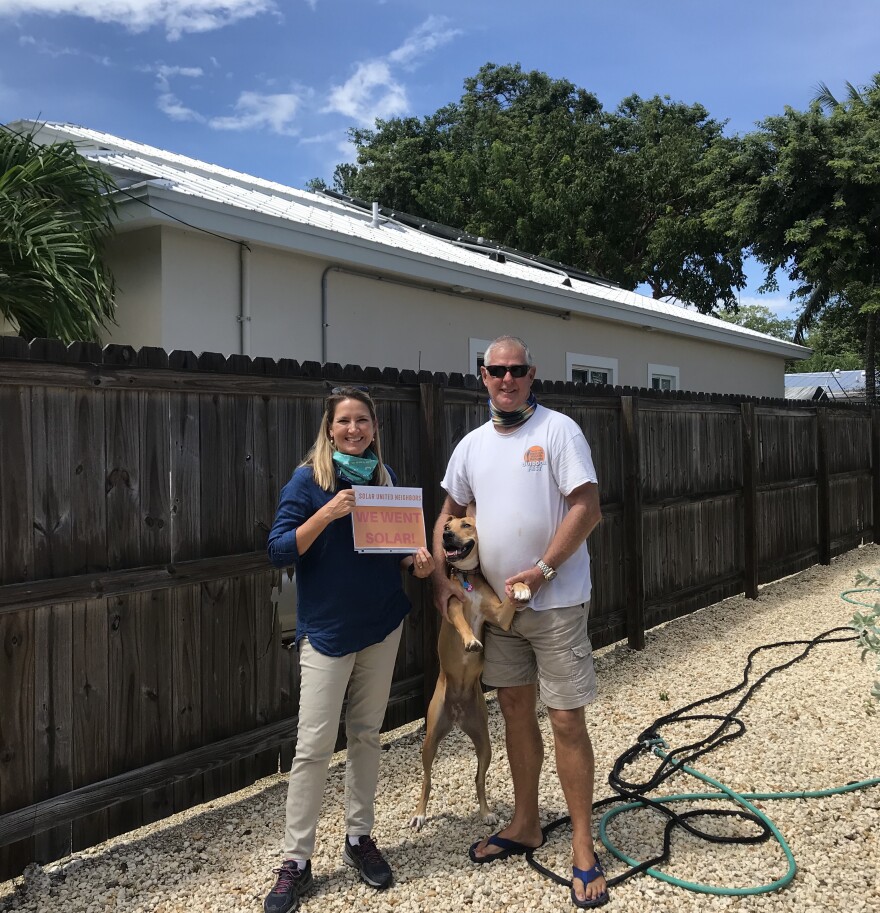 A Key Largo couple who installed solar power through Solar United Neighbors, with their dog