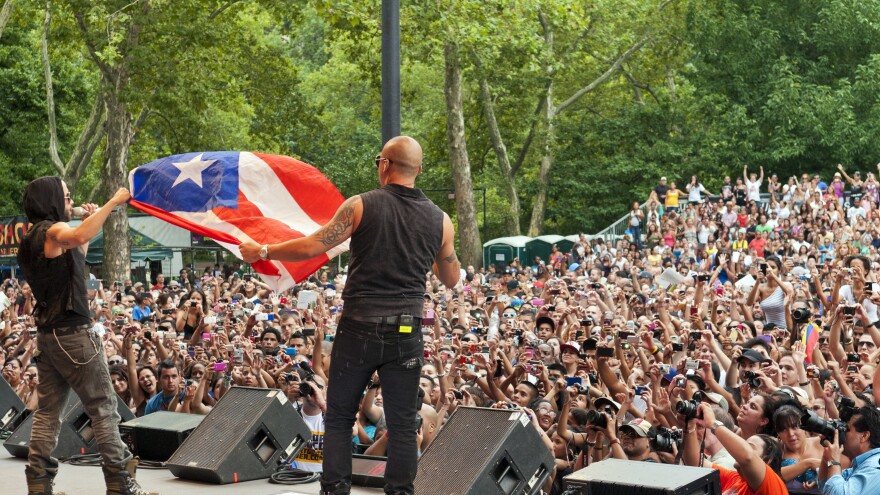 Wisin y Yandel wave the flag of Puerto Rico during a performance in Central Park on  August 13, 2011.