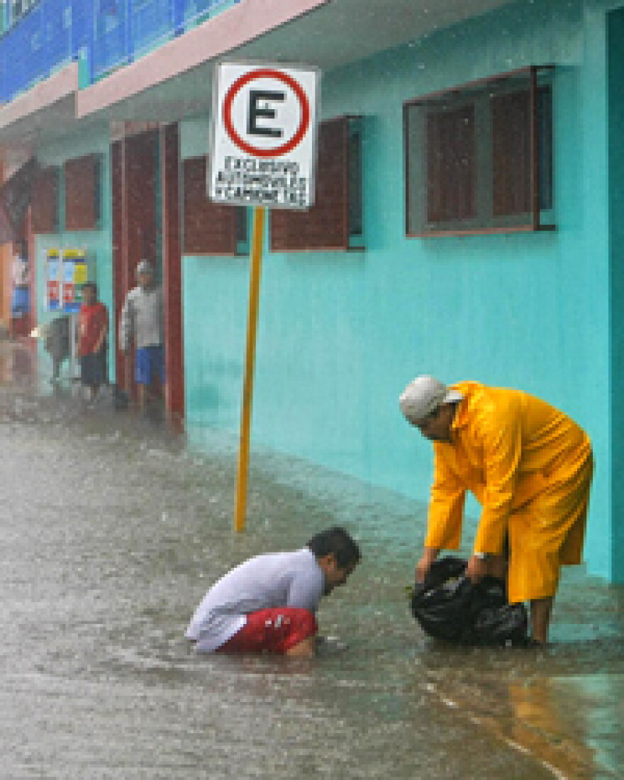 Residents try to clear a drain during flooding in Chetumal, where officials declared a red alert.