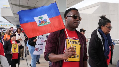 A man carries a Haitian flag during a rally 
