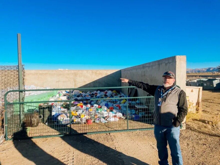 Colby Earley stands in front of the #2 plastics at the Cortez Service Center. These will eventually be brought to the Montezuma County landfill to be baled and sent out with other #2 plastics from around the county.