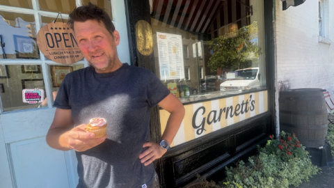 Garnett's manager John Murden holds a cupcake, given to customers on their 17th birthday, celebrated earlier this month. 