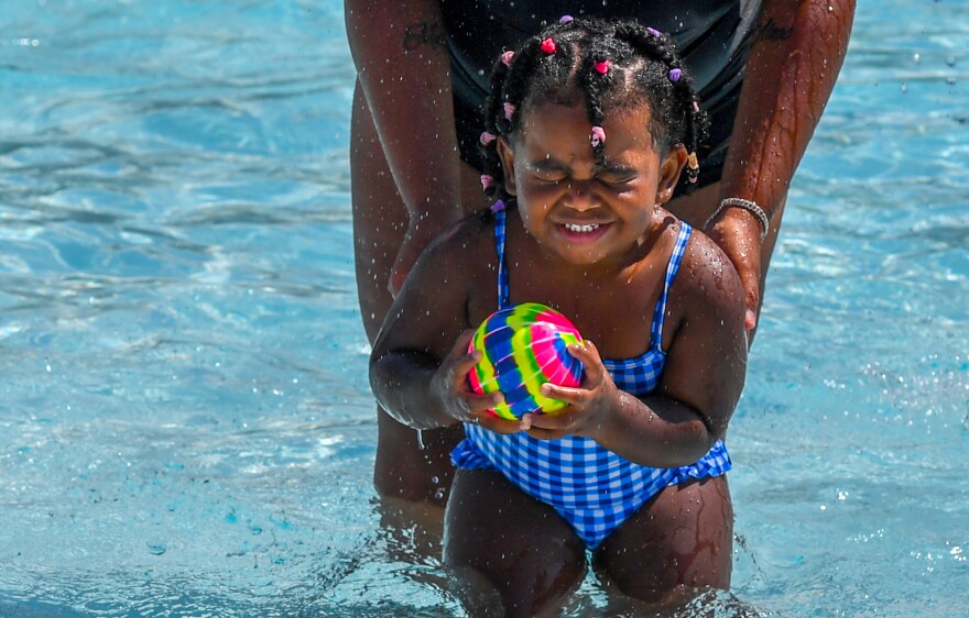 Makayla Johnson, 2, is held by her mother at Weston Park's pool in Scranton.