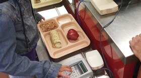 FILE - In this Thursday, May 4, 2017 file photo, a third-grader punches in her student identification to pay for a meal at Gonzales Community School in Santa Fe, N.M. All students are offered the same lunch at Gonzales and other Santa Fe public schools to avoid any chance of embarrassing students whose parents may have fallen behind on meal payments. In April 2017, New Mexico became the first state to outlaw the shaming of children for any unpaid meals. (AP Photo/Morgan Lee)