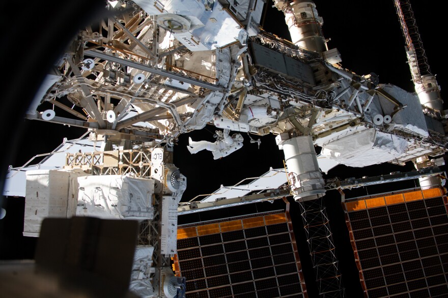 Expedition 59 flight engineers Anne McClain of NASA (red stripes) and David Saint-Jacques of the Canadian Space Agency work outside the International Space Station in April.