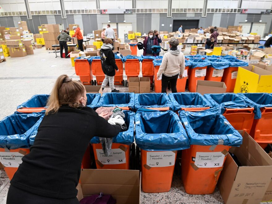 Volunteers from the aid organization "Borderless Warmth" sort relief supplies for Ukraine at the Westfalenhalle in Dortmund, western Germany.