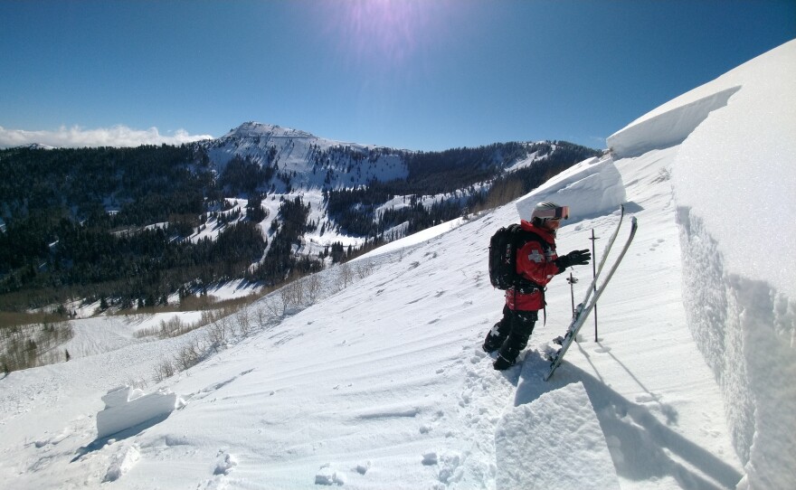 A ski patroller assesses an avalanche triggered by explosives.