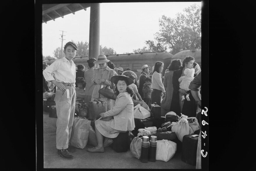 Japanese families in Woodland, California wait for train at railroad station to take them to internment camp. May 20 1942.