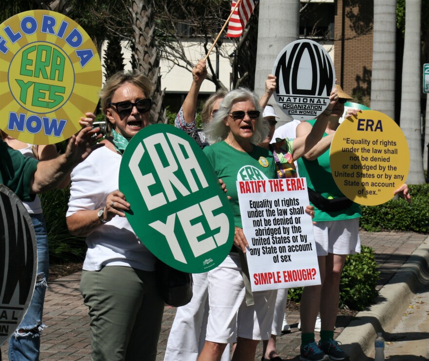 Activists hold signs supporting ERA