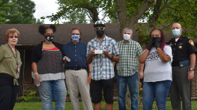 Members of the Story Chain family present Javon Yoakum with an MP3 player loaded with stories his family and friends have recorded especially for him. From left to right: Dee Yoakum, Felicia Chappelle, Jonathan Platt, Javon Yoakum, Josh Carson, Mary Evans and Major Kirk Keller.