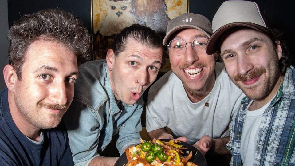 Post Sex Nachos members — guitarist Mitch Brodden, drummer Hunter Pendleton, bassist Chase Mueller and lead singer Sammy Elfanbaum — pose with a plate of their namesake, courtesy of The University Library Cafe in Des Moines.