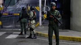 Soldiers guard the area around the Miraflores presidential palace after explosions and low-flying aircraft were heard in Caracas, Venezuela, Saturday, Jan. 3, 2026. (AP Photo/Cristian Hernandez)