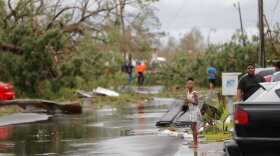 Tamiya Waldon looks out at the damage to her neighborhood in the aftermath of Hurricane Michael in Panama City, Fla., Wednesday, Oct. 10, 2018. (AP Photo/Gerald Herbert)