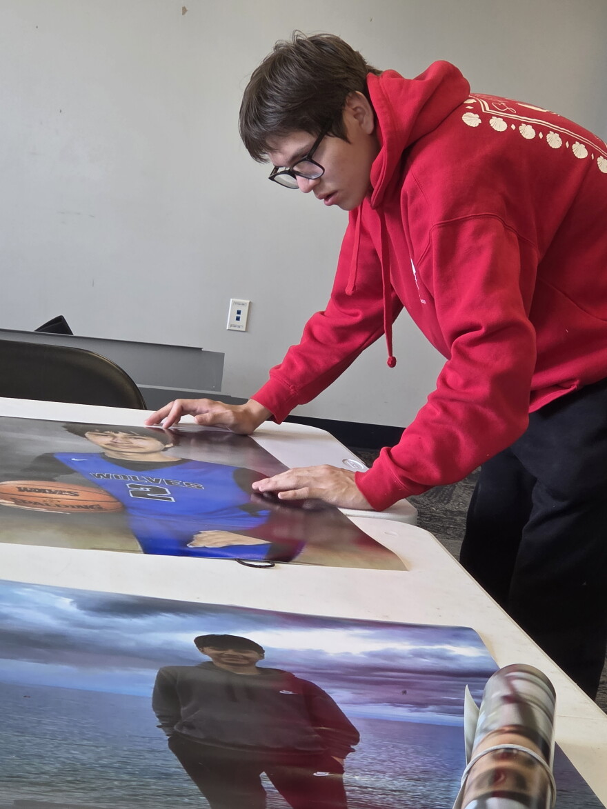 Tony Fairbanks wipes off the posters of Dylon Oothoudt dampened by rain from the last night's vigil in Cass Lake, at the Onigum Community Center on Sept. 16, 2026. Fairbanks was Oothoudt's cousin and a close friend.