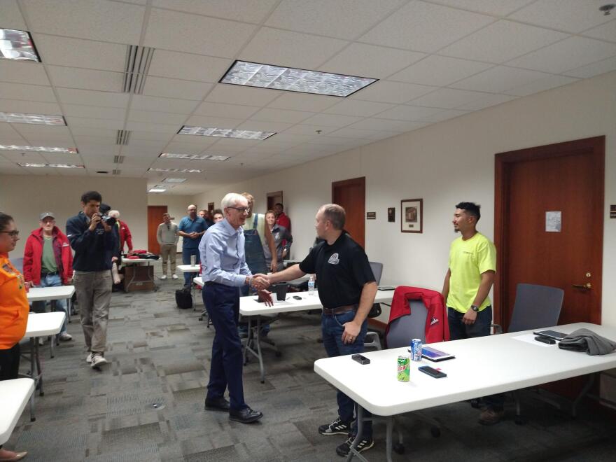 Gov. Tony Evers shakes hands at the Carpenters Union offices in Pewaukee, during a recent campaign stop.