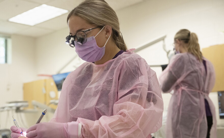 Tycee Thivierge works on a patient's teeth through part of an NIC training program on Thursday, Oct. 1 at 450 11th Ave in Lewiston.