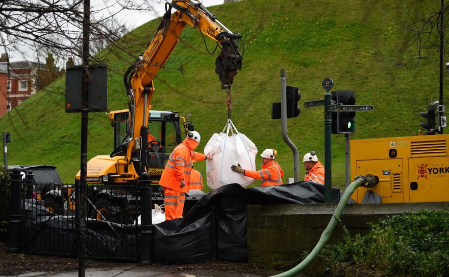 Emergency workers put barricades in place in York, North Yorkshire, on Saturday as Storm Dennis sweeps in over the U.K.
