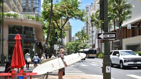Tourists in Waikīkī with surfboards