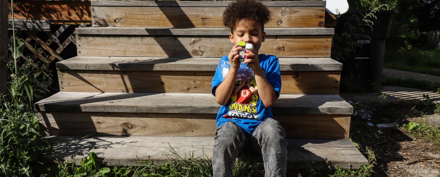 Cayden Dillon, age 7, sits on the wooden steps of his Slavic Village home.