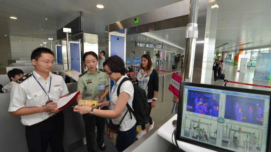 Chinese customs officials, like the ones shown here in August at the Lukou International Airport in Nanjing, have broad powers to confiscate items. One woman who had copies of her father's memoir seized has sued the government.