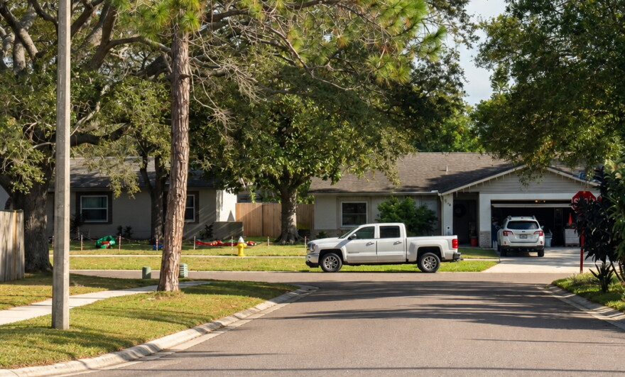 View of houses with a truck on the side of the road and a car in the driveway