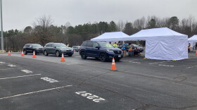 Patients wait in their cars to get first doses of a COVID-19 vaccine at PNC Arena in Raleigh.