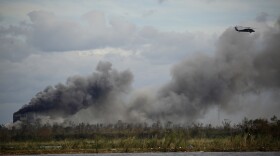 A helicopter flies over a chemical fire at BioLab plant after Hurricane Laura made landfall in Westlake, La., on Aug. 27, 2020.