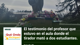  En la imagen se puede observar el monumento de Spartan en Michigan State University. El monumento esta rodeado de flores y mensajes a las victimas que murieron cuando un tirador entro a la universidad.  En el lado inferior de la imagen esta el logo de ¿Qué Onda Michigan? sobre un fondo blanco. En la parte derecha las siguientes palabras estan escritas: "El testimonio del profesor que estuvo en el aula donde el tirador mato a dos estudiantes." En el lado superior de la imagen se encuentra las palabras "WKAR" en color blanco.  y "Episodio 80".