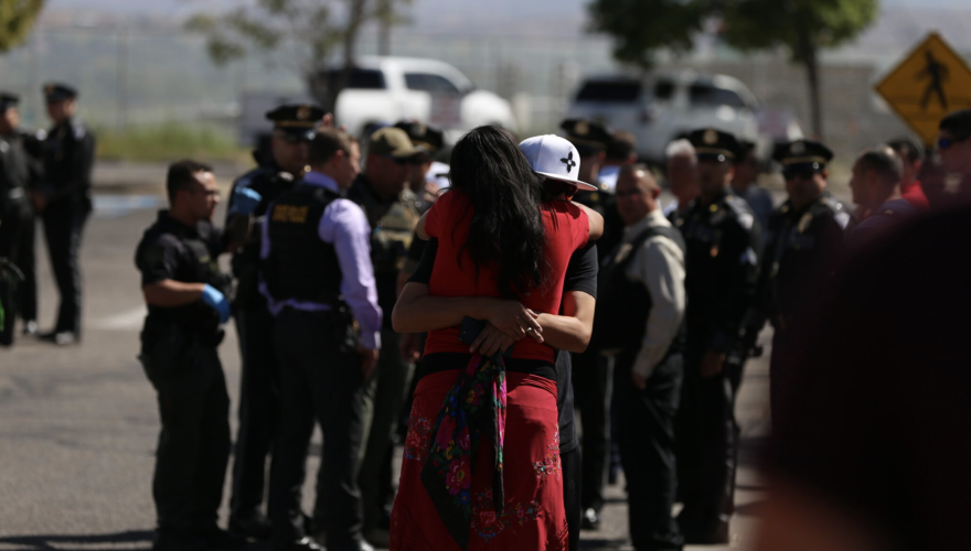 People hug after a shooting in Española during a prayer event to oppose the reinstallation of a statue of conquistador and war criminal Juan de Oñate.