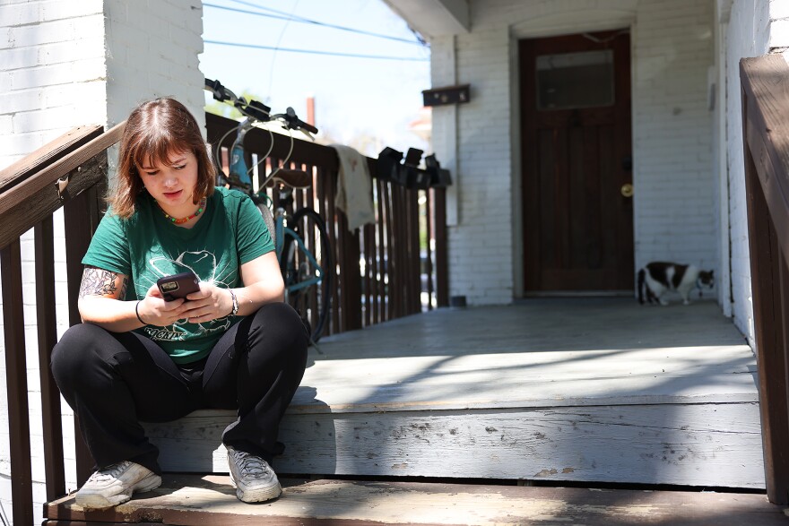 Kelaiah Killmade takes their cat outside on Friday, April 14, 2023, at their East Campus apartment in Columbia. “She’s really pissed at me right now because I took her to the vet the other day, and she had to get bloodwork done,” Kill said. “So she’s been ignoring me for like three days.” 