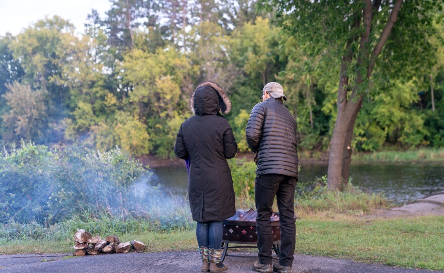 Attendees warm up around fire rings during Grand Rapids Riverfest on Sept. 6, 2025.