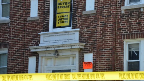 A bright orange signs warns people not to enter the buildings.