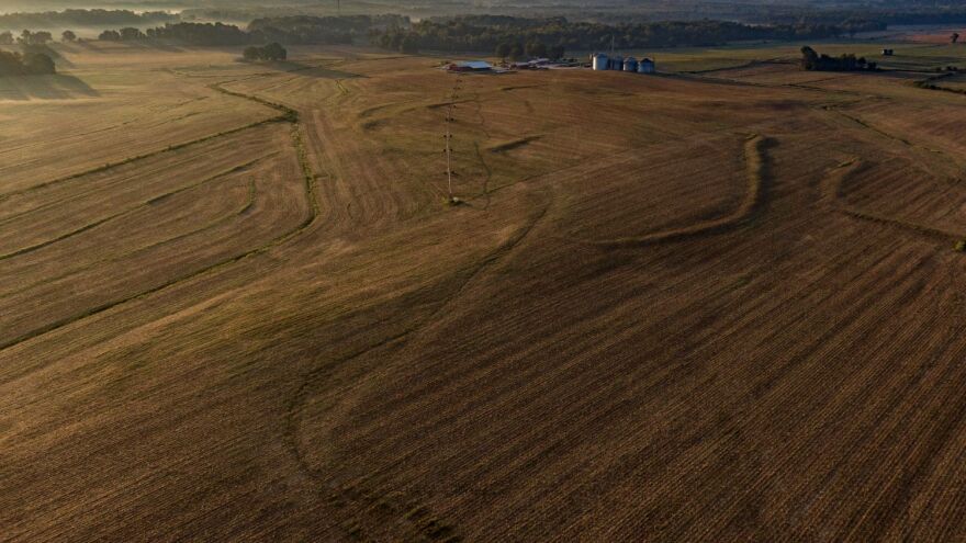 A brown tilled farm field as seen from the sky.