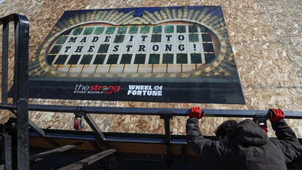 Workers move the original pre-1997 “Wheel of Fortune” puzzle board into The Strong National Museum of Play in Rochester, N.Y., on Monday, March 2, 2026. The massive board — used on the television game show Wheel of Fortune when co-host Vanna White manually turned the letters — was transported across the country over six days and brought into the museum through a temporary opening in an exterior wall. The artifact will be featured in the museum’s upcoming “Beyond the Buzzer” exhibit on the history of American game shows.