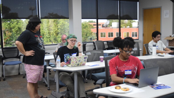 Paul Chin, left, helps Belinda Terry, center, with her code on HTML Day during an event hosted by 757 Tech on Aug. 8, 2026.