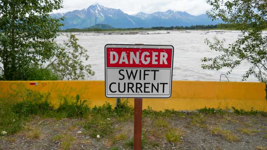A danger sign and barriers sit against the Matanuska River bank near Palmer on July 6, 2025. The area is one of a handful set for fixes under a new state project.