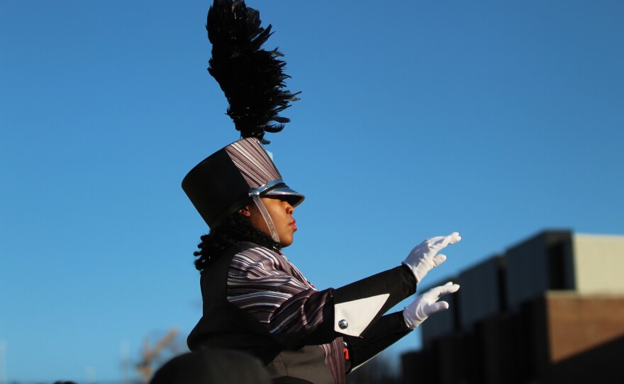 Fans and marching band members greet ISU football players and coaches