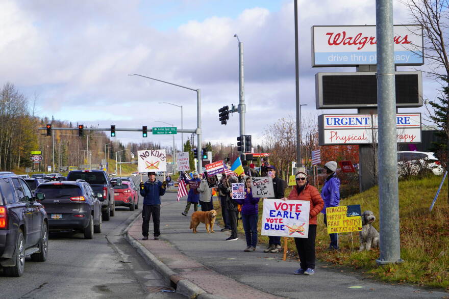 Protesters wave signs along the Sterling Highway in Soldotna, Alaska, on Saturday, Oct. 17, 2026.