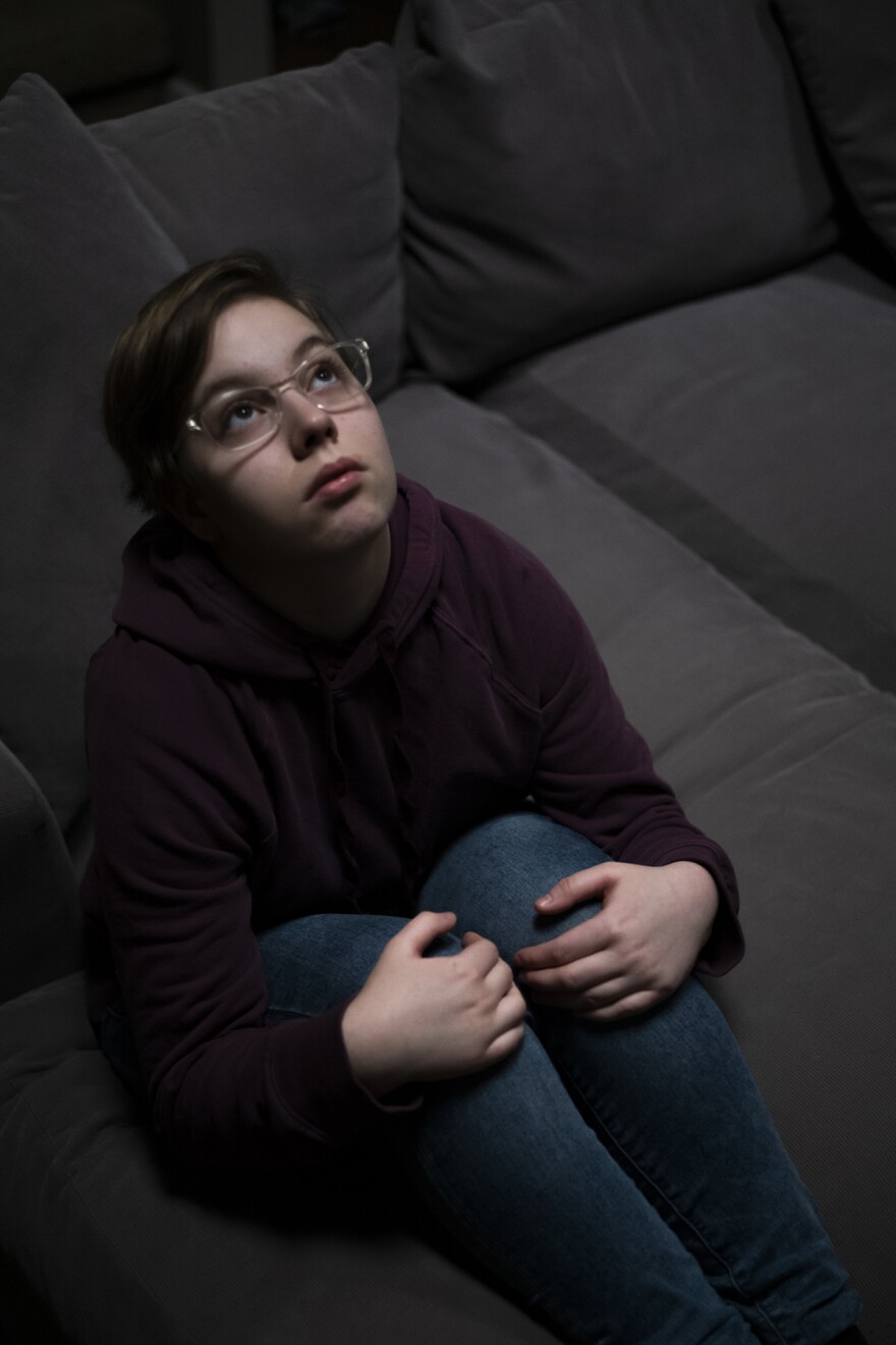 a child sits on a couch and looks up at the ceiling