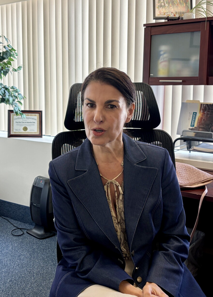 Mireille Sayaf, executive director of the Ocean State Center for Independent Living, speaks to a reporter in her Warwick office, Aug. 27, 2026. Credit: Ocean State Media/Paul Singer