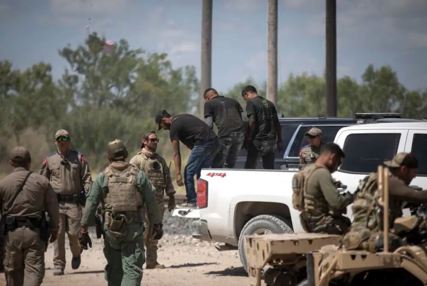 A group of migrants walk off a pickup truck after being apprehended by Department of Public Safety officers at a train depot in Spofford on Aug. 25, 2021. U.S. Border Patrol agents took into custody women and children found with the same group.