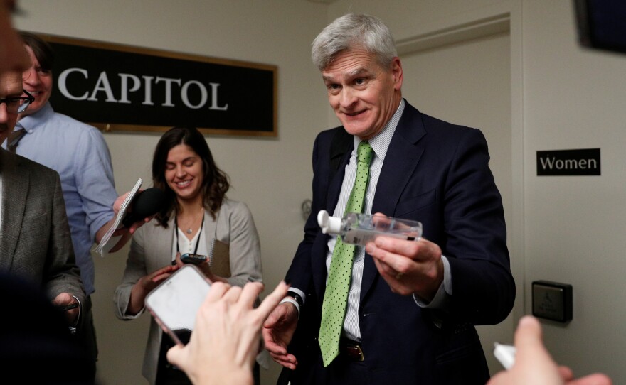 Sen. Bill Cassidy, R-La., gives news reporters hand sanitizer following a Senate hearing on the coronavirus on Capitol Hill Tuesday.