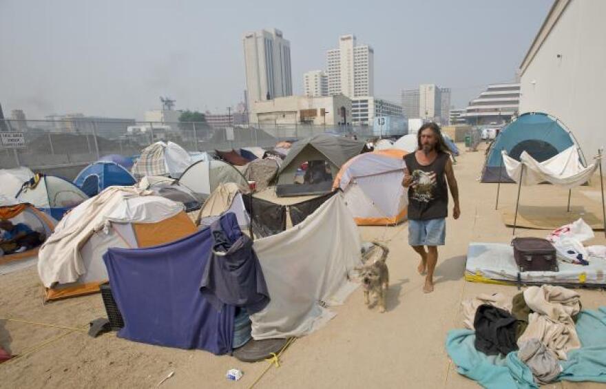 Robert Scott Cook, originally from Alaska, walks his dog Tramp through the tent city that sprang up next to the homeless shelter in downtown Reno, Nev., Wednesday, June 25, 2008. The tent city that sprang up during the recession may be gone but there are still homeless in need of help in Reno.