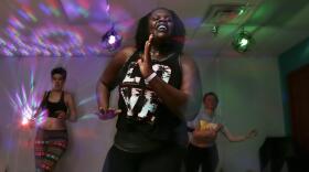 Leonte Paul, 33, leads a Zumba class at Positive Force Movement as Jess Whitehouse, 30, and Angela Hakkila, 37, dance behind her. MAX SCHULTE / WXXI NEWS