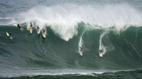 Five surfers drop down the face of a large wave at Waimea Bay located on the north shore of the island of Oahu Monday Dec. 7, 2009. The Quiksilver in Memory of Eddie Aikau surf contest was postponed because the surf did not reach the 30-40 foot wave high requirement. (AP Photo/Eugene Tanner)