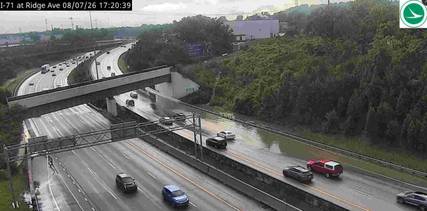 Traffic passes standing water on a highway curve.
