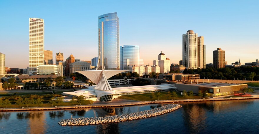 An artist's rendering of Milwaukee's downtown skyline shows a modern office tower with glass exterior next to a similarly styled but taller tower, with the art museum and Lake Michigan shoreline in the foreground.